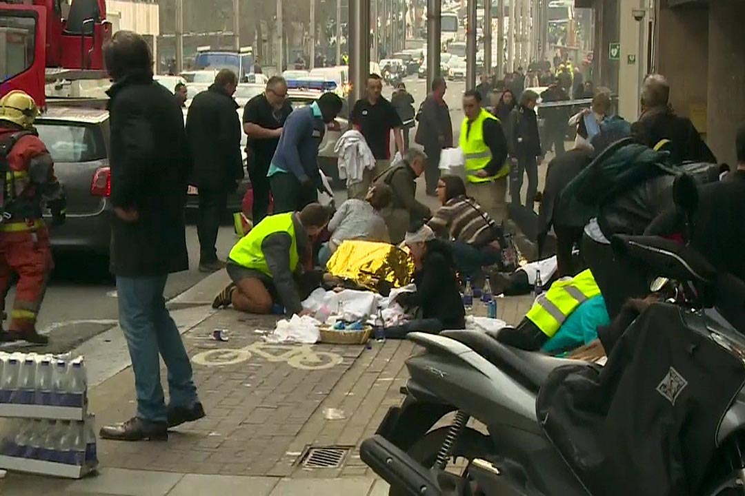 2016年3月22日,比利時布魯塞爾馬爾比克(Maelbeek)地鐵站發生爆炸後,救援人員在地鐵站外照護傷者。攝:RTL Belgium via Reuters