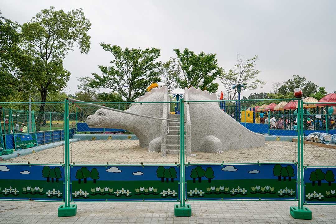 大安森林公園遊戲場原本規劃一座塑膠遊具所在處,在一群父母抗議之下,改為一組恐龍磨石子溜滑梯。攝:張國耀/端傳媒
