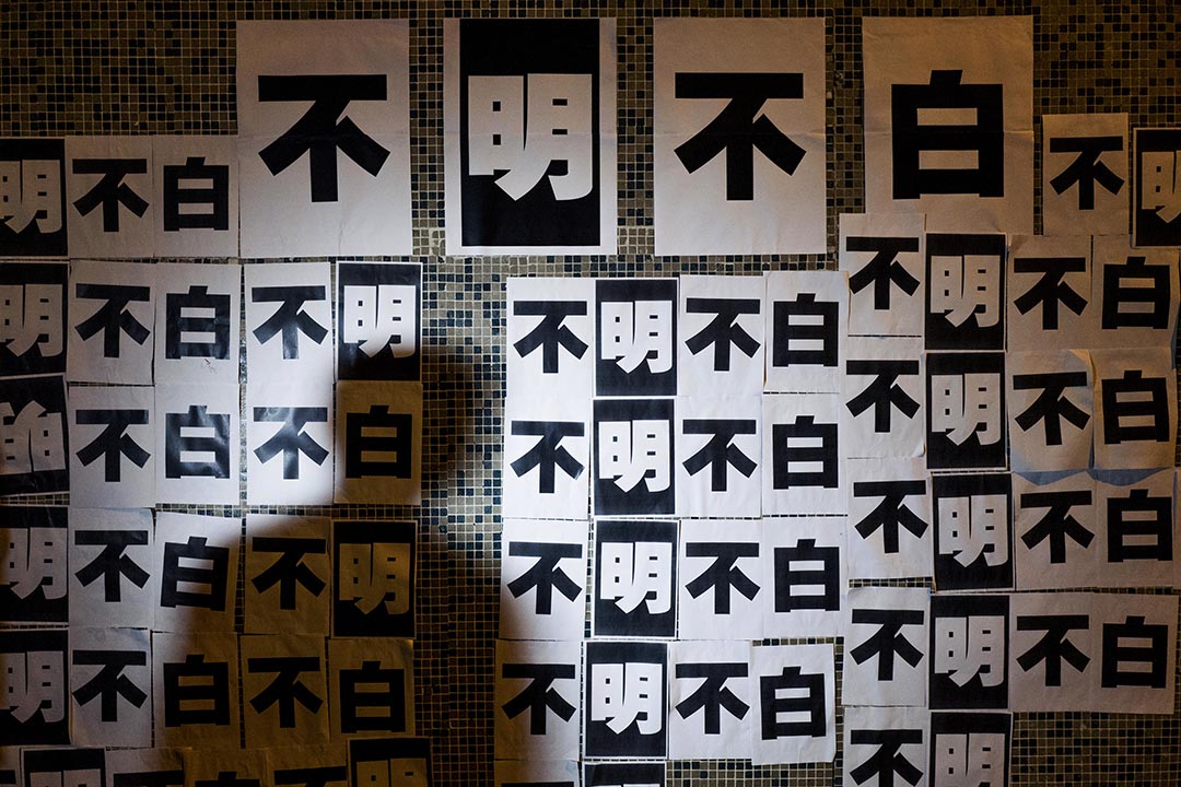 員工於明報集團大樓外牆張貼「不明不白」標語示威,表達對管理層決定的不滿。攝 : Anthony Kwan/端傳媒