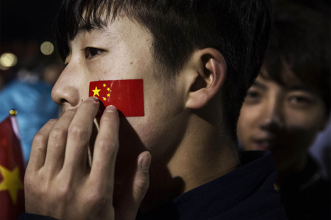 2015年10月1日，中国北京天安门国庆升旗礼中，一个青年摸著面颊上的国旗图案。