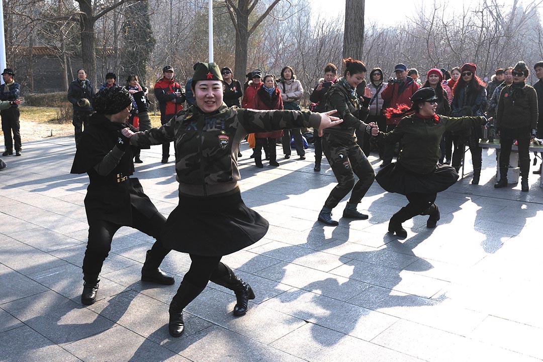 北京陶然亭公園,大媽們身穿迷彩製服,頭戴貝雷軍帽,盡情舞動展現風采。