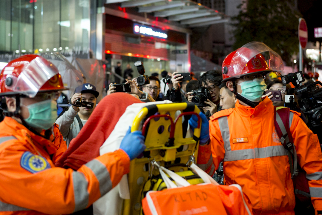 港鐵縱火案後,救護員在尖沙咀港鐵站外運送傷者往醫院治理。