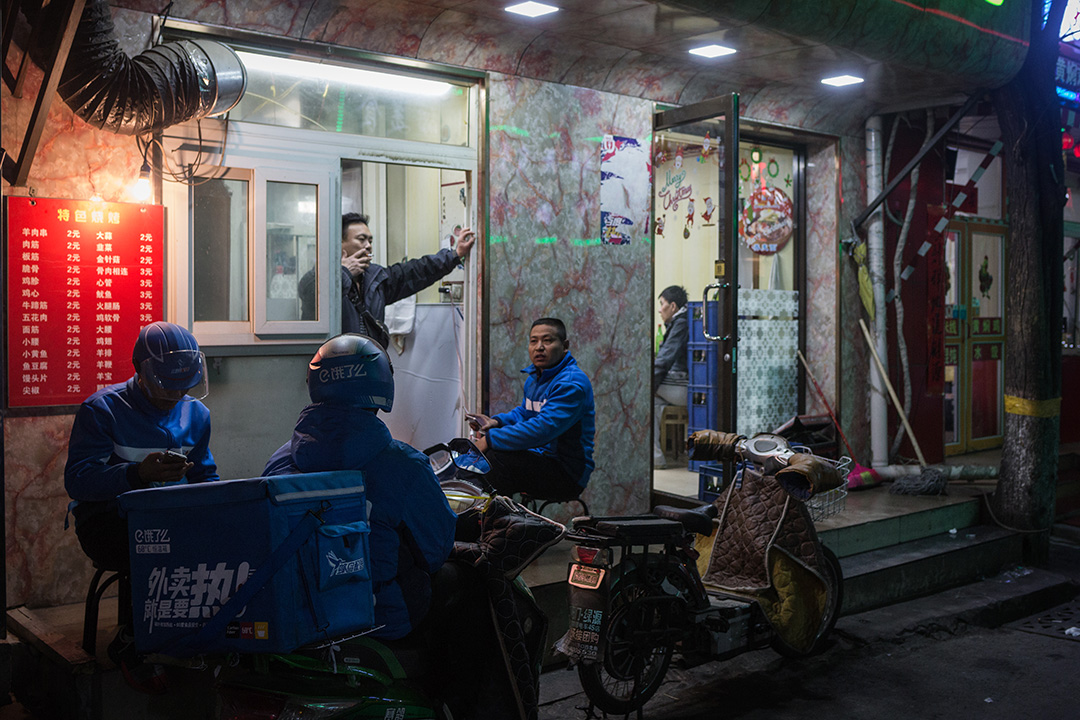一群外卖员在食店外歇息,等待客人的订单。
