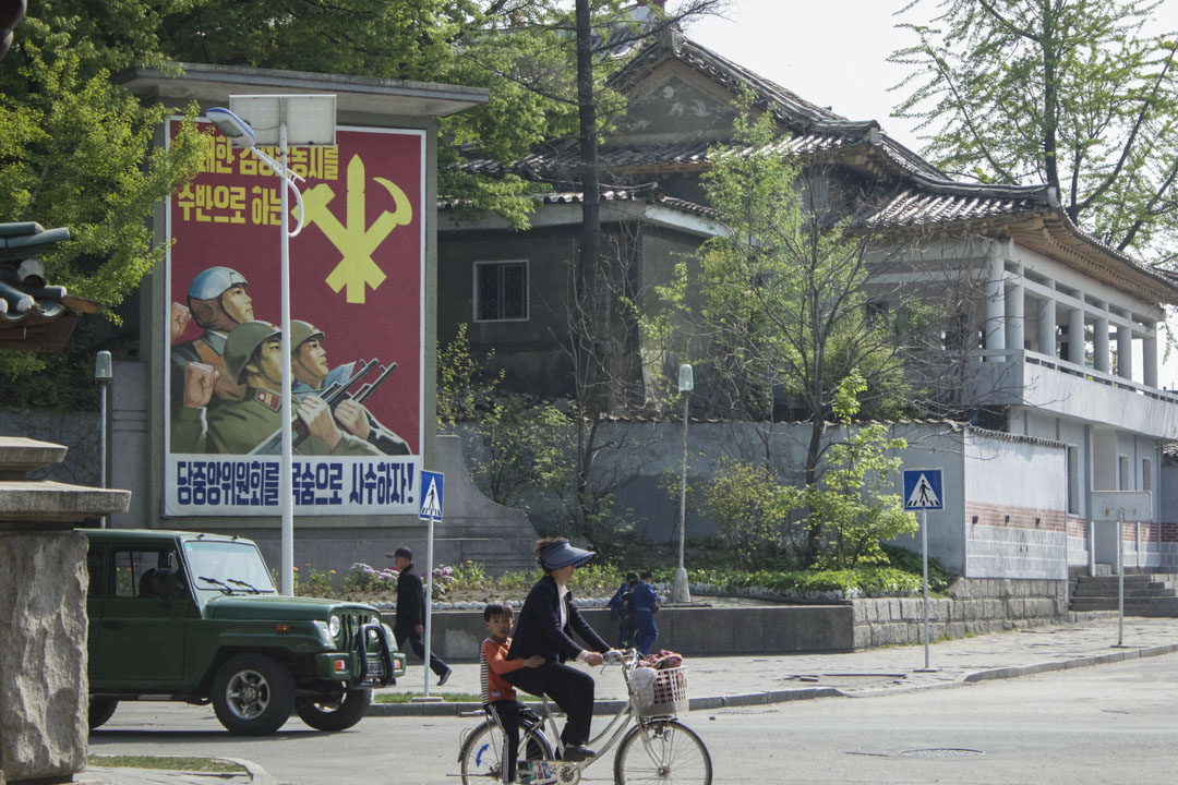 北韓旅行團所拍攝的當地街道,一位市民載著小孩踏單車。