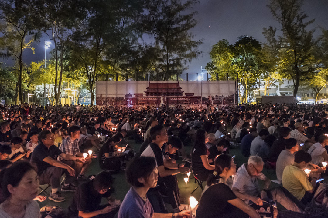 2017年6月4日,香港维园举行六四晚会。参与者在天安门广场的大横幅旁,手持烛台,悼念天安门事件中的死难者。