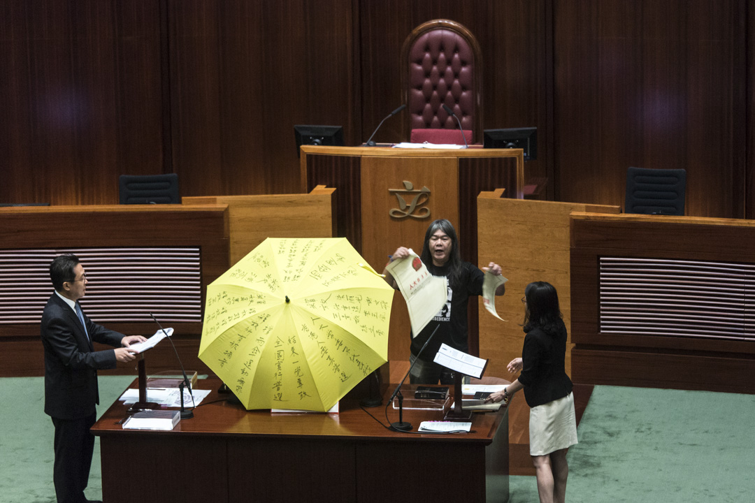 2016年10月12日,香港立法會議員梁國雄於宣誓時,手持黃色雨傘並撕毀一張代表人大831決議的道具。