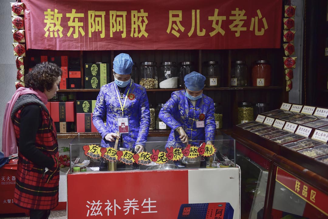 浙江省义乌的三溪堂国药馆,两名工作人员示范熬制阿胶。
