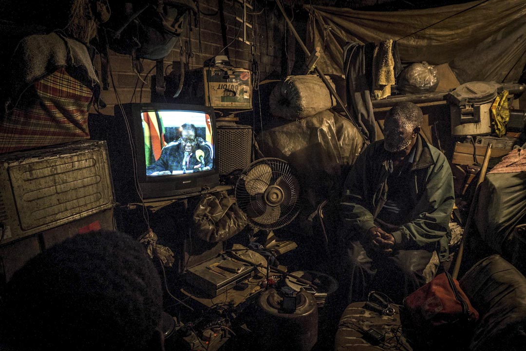 2017年11月19日,一名津巴布韋市民在簡陋的家中觀看總統穆加貝(Robert Mugabe)的電視講話。