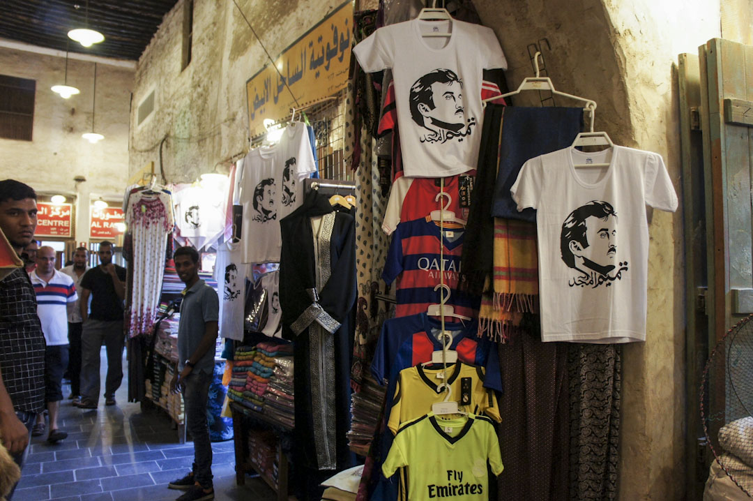 走进拥有百年历史、当地规模最大的交易中心瓦奇夫市集（Souq Waqif），挂在店门口、作为招徕的热卖款，往往是印著埃米尔的“周边商品”。