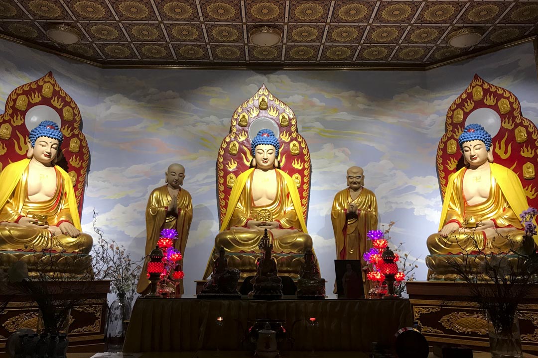 四方四正的佛堂約一百多平米,正中擺着三尊佛像——釋迦牟尼、阿彌陀佛和藥師佛——每尊佛像旁邊,都有兩位菩薩的立像,是大雄寶殿常見的式樣。