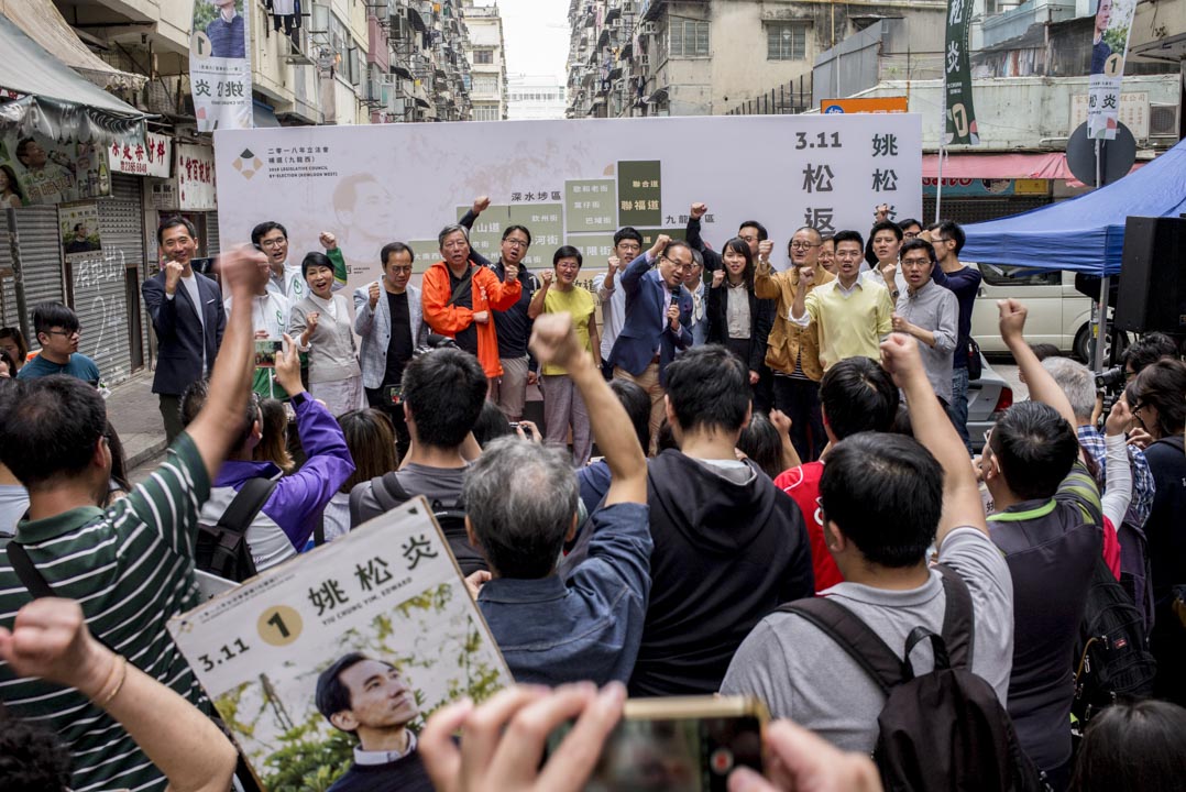 「3·11」立法會補選,民主派陣營因而主打「反DQ」、「反北京專制」。姚松炎競選團隊亦相信選民會關心「DQ」議題,宣傳單張及橫幅均印上相關口號。圖為2018年3月4日,姚松炎造勢大會在土瓜灣舉行,不少民主派人士都站台撐場。