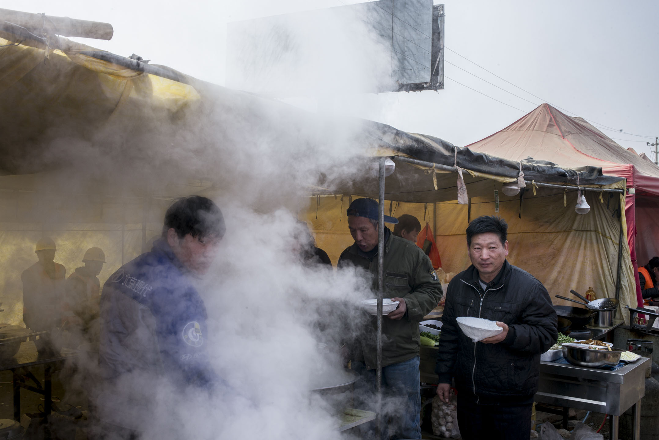 位於容城東部,投資8億元、佔地10萬平米的雄安市民服務中心正在熱火朝天地趕工。這裏將承擔雄安新區的政務服務、規劃展示、會議舉辦、企業辦公等多項功能。施工中的午飯時間,工人們都在工地外的大食堂吃飯。