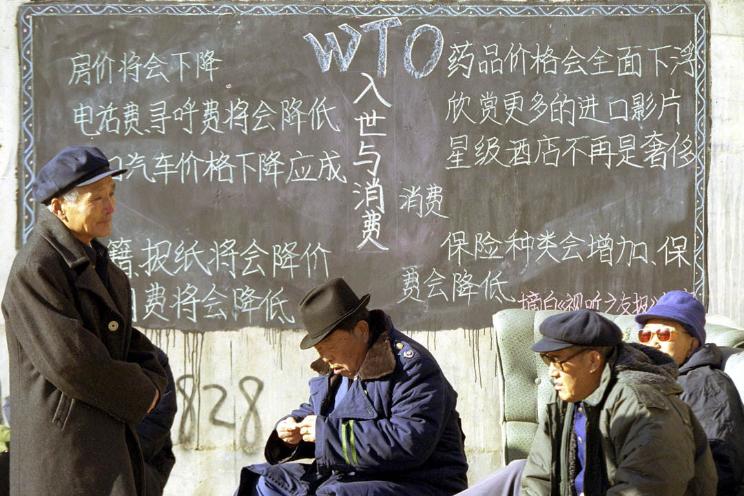 经过15年漫长的谈判,中国终于在2001年12月11日正式成为世贸组织 第43名成员 。图为当年北京市内的一块宣传加入世贸好处的黑板前。
