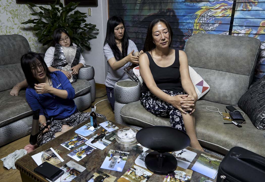 南韓堤川市,薩滿法師Cheonsindangju閉著眼享受弟子為她梳頭。