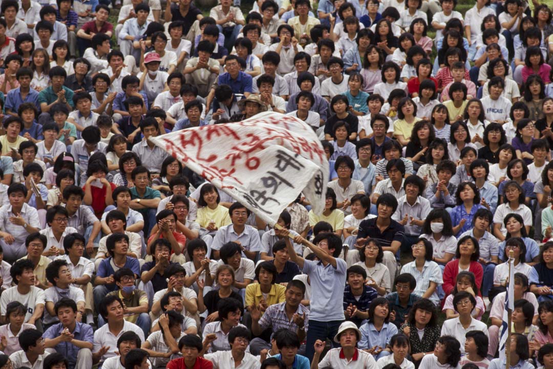 韩国于80年代发生的一系列民主运动,因为卫星电视的出现,台湾和中国的学生又模仿了韩国的学生运动和民主化运动。图为1987年的韩国学生运动。