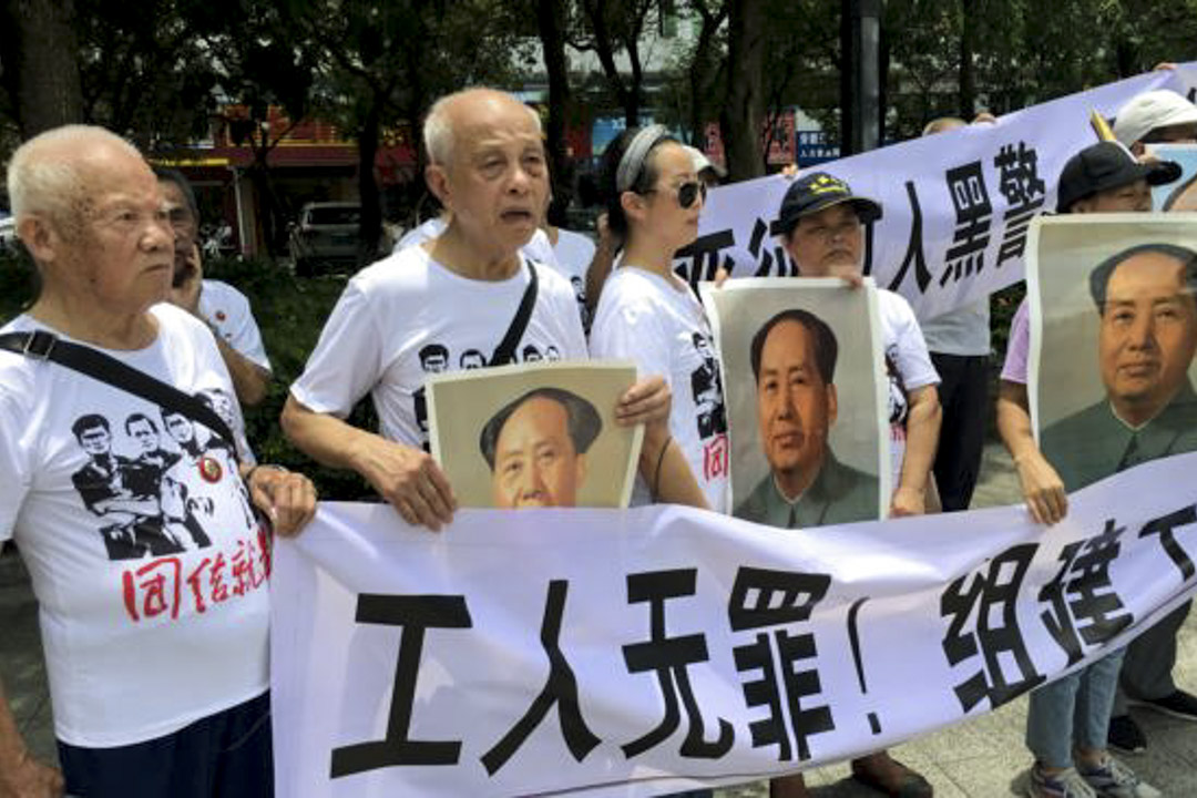 2018年8月6日,市民在中國廣東省深圳市坪山區燕子嶺派出所外示威,手持標語及毛澤東肖像,支持佳士工廠工人。