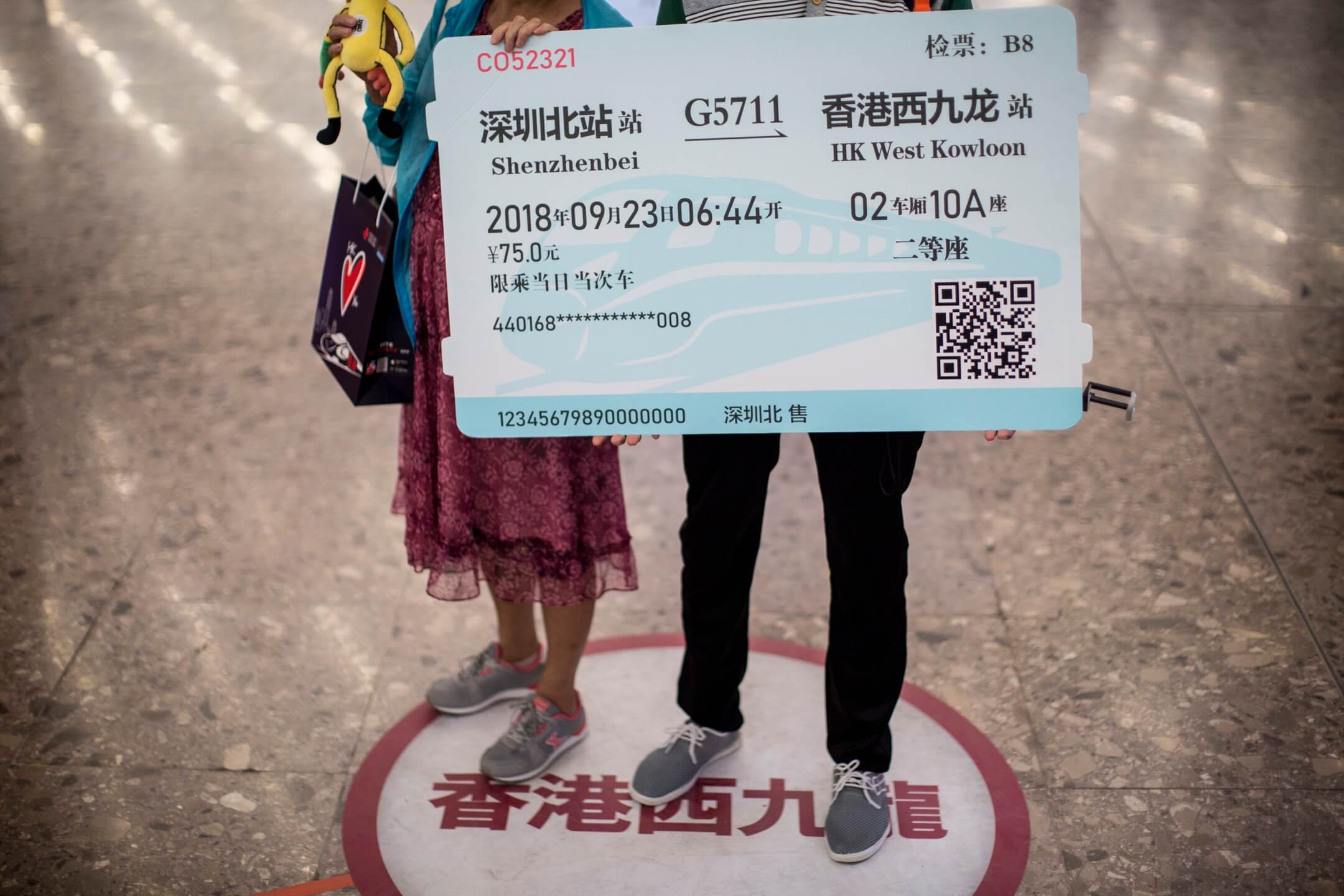 香港西九龙高铁站入境大堂,两名内地旅客拿著道具车票拍照。