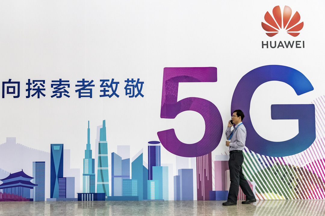 2018年9月26日,中国国家会议中心举办的PT Expo China 2019期间,一名男子在华为5G广告牌前用手机讲话。