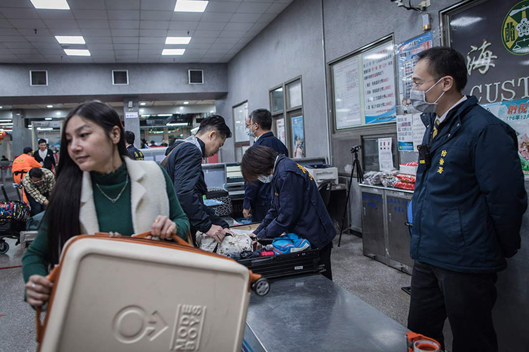 2019年1月4日,金門水頭碼頭工作人員正檢查訪台旅客的行李。