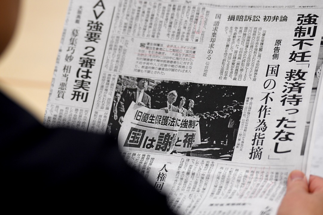 一名被強制絕育的受害者在閱讀報紙裏一則相關的報導。