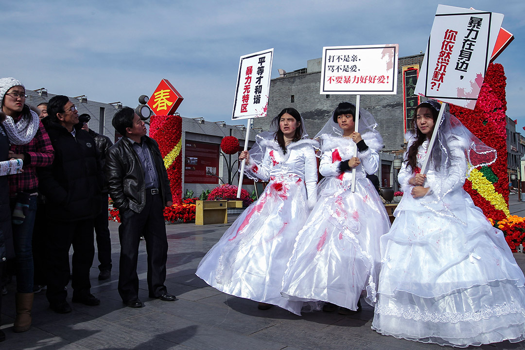2012年2月14日情人节,三名女孩在北京市街头穿上血淋淋的婚纱,为家庭暴力受害者抗议。