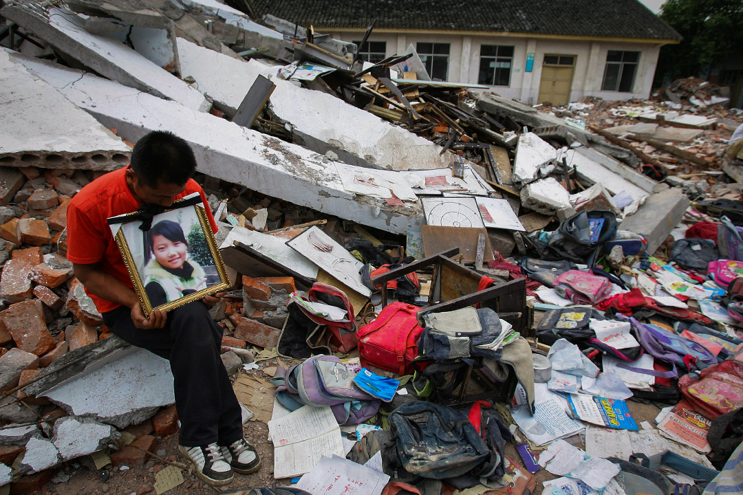 2008年5月20日,四川省綿竹市的學校,一名父親參加一場哀悼和抗議活動,其女兒在地震因校舍倒塌而壓死。