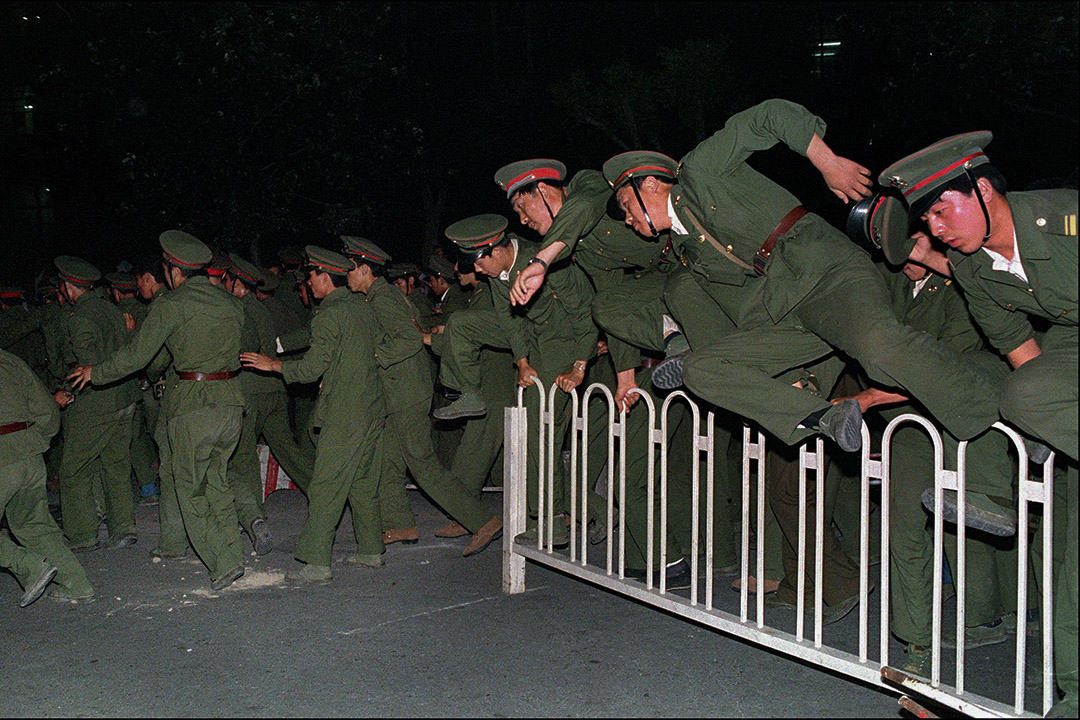 1989年6月4日,解放軍與示威者發生激烈衝突,士兵在天安門廣場上跨越障礙物。