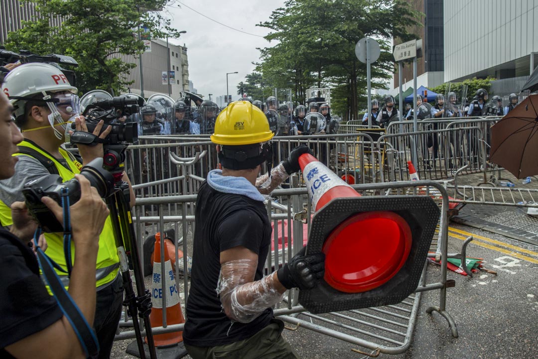 2019年6月12日，一名示威者与警察对峙时，拿起雪糕筒。