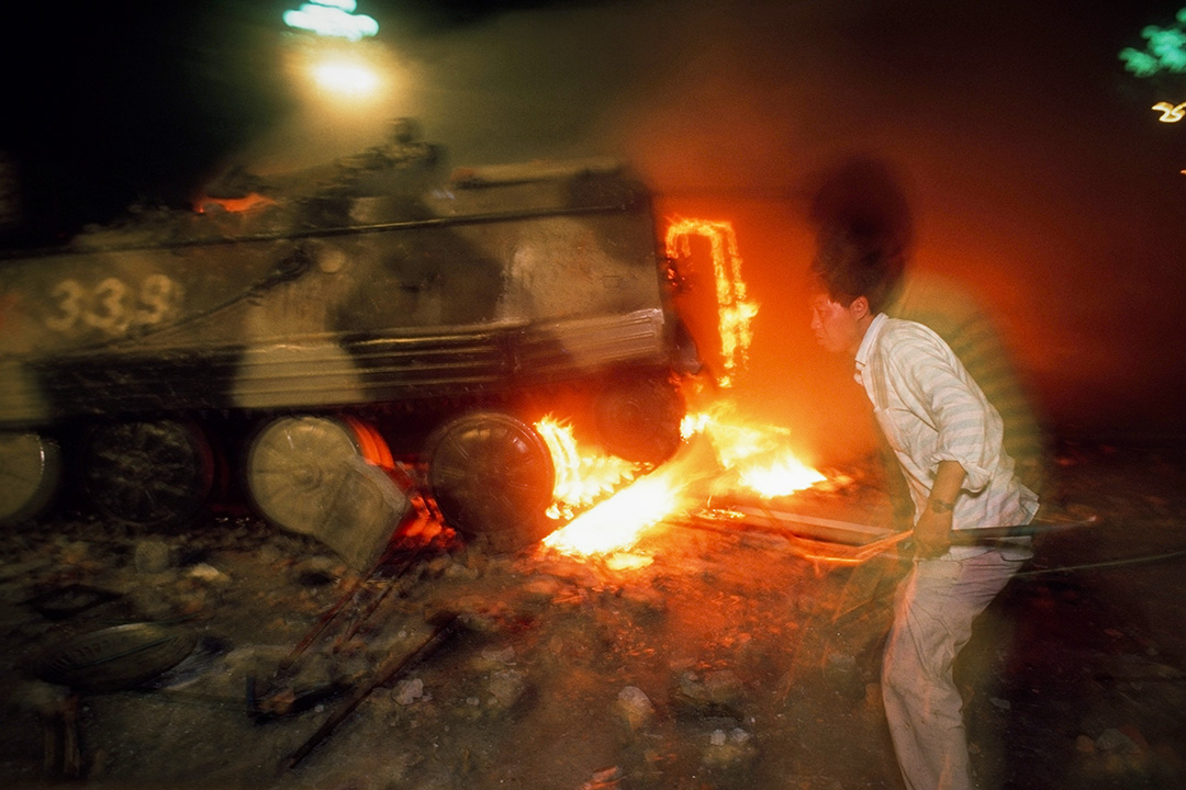 1989年6月4日,一名示威者與一輛燃燒的裝甲運兵車。