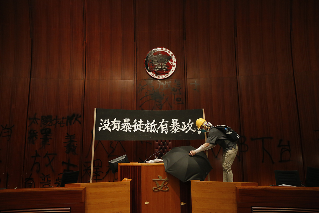 2019年7月1日，示威者闯入立法会会议厅，在主席台后方的墙上喷字、竖起标语，并涂污特区区徽。