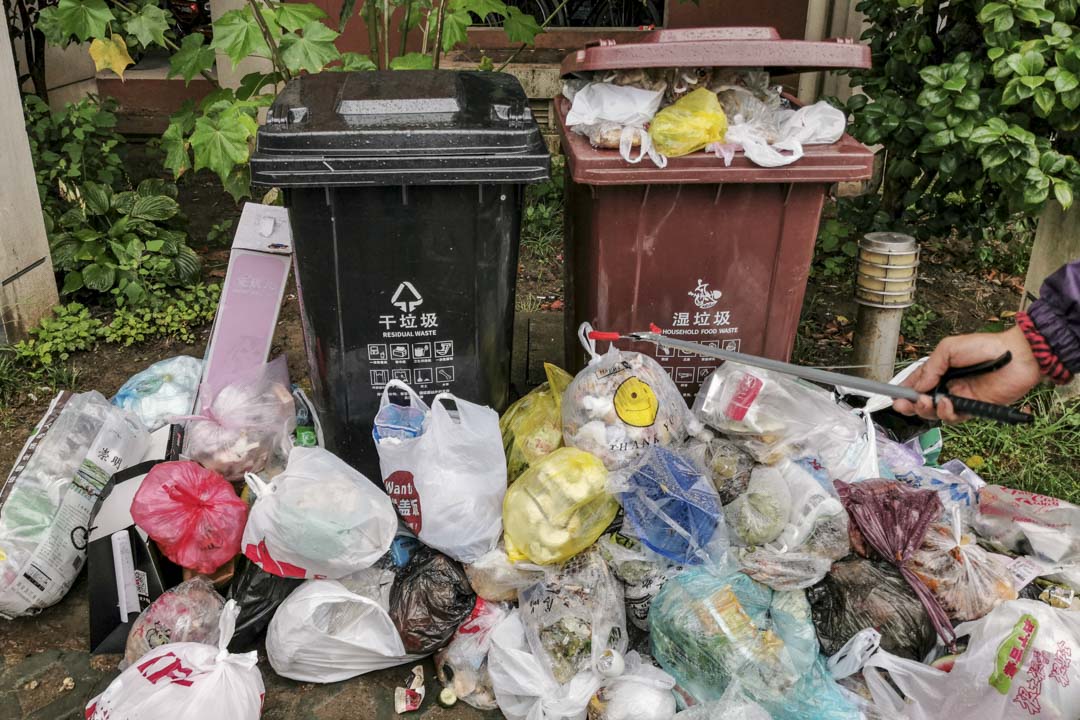 2019年7月10日,上海小區的分類垃圾桶外堆滿了袋裝垃圾,這些垃圾中多數是來不及清運的濕垃圾。