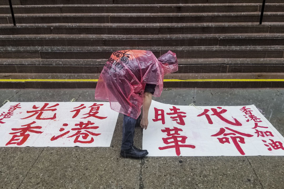 写有“光复香港,时代革命”的白布在雨中。