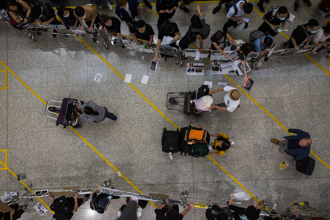 港人在機場發起「警察還眼」集會,機場方面以鐵馬圍起供旅客離開的通道。