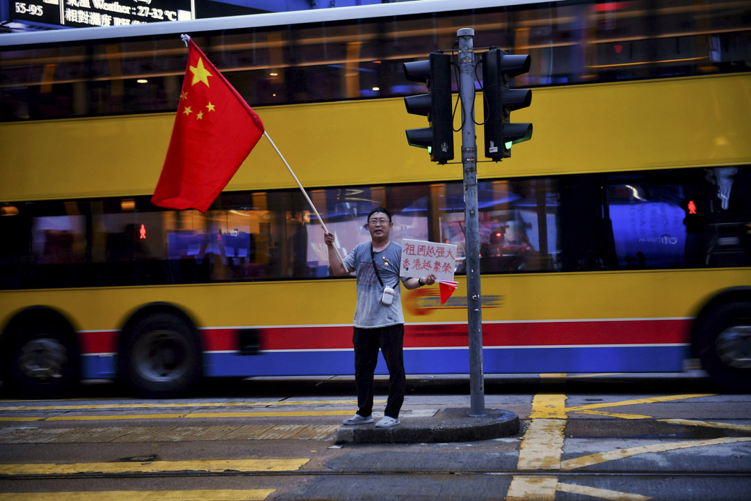2019年8月26日,一位市民在香港中環揮動中國國旗。