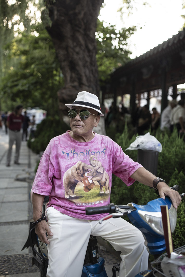 公园里一位打扮时髦的男士,他说身上这件T恤是去泰国旅游时买的。