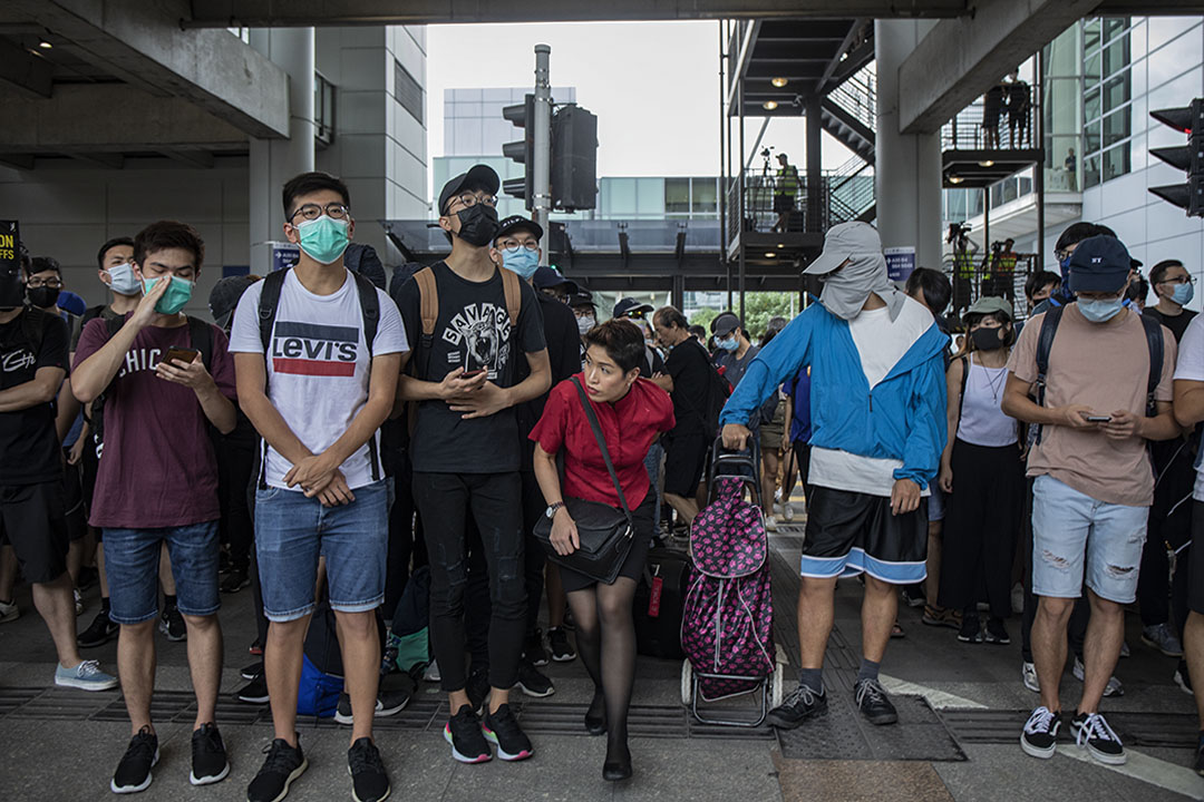2019年9月1日,示威者包圍機場,意圖癱瘓機場運作,一名空中服務員穿過示威的人群。