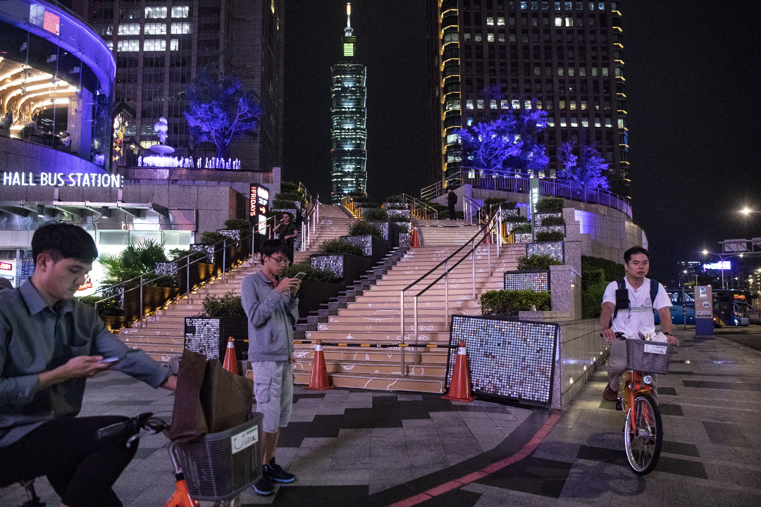 台北信义区,行人正等候过马路。