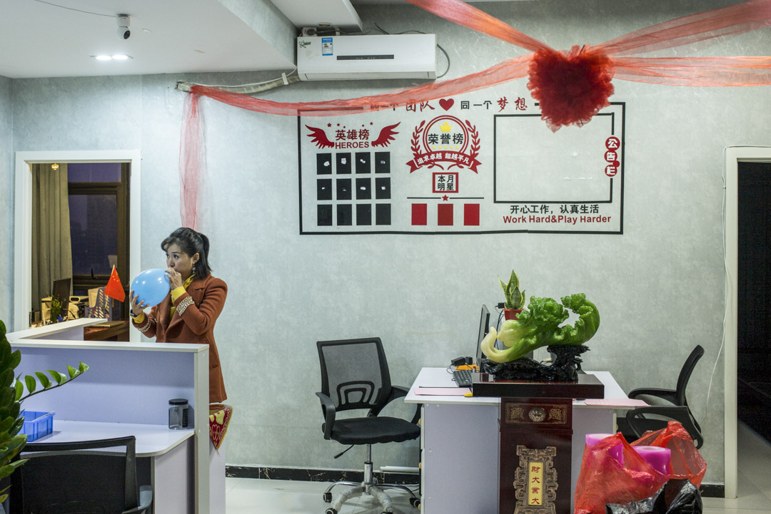 婚介公司的職員在婚禮當天的清晨,忙着佈置「娘家」及吹氣球。
