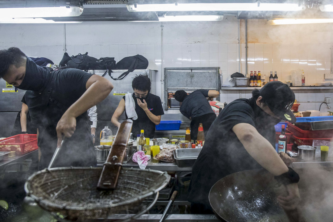2019年11月14日,理大留守者在飯堂戴著口罩煮食。
