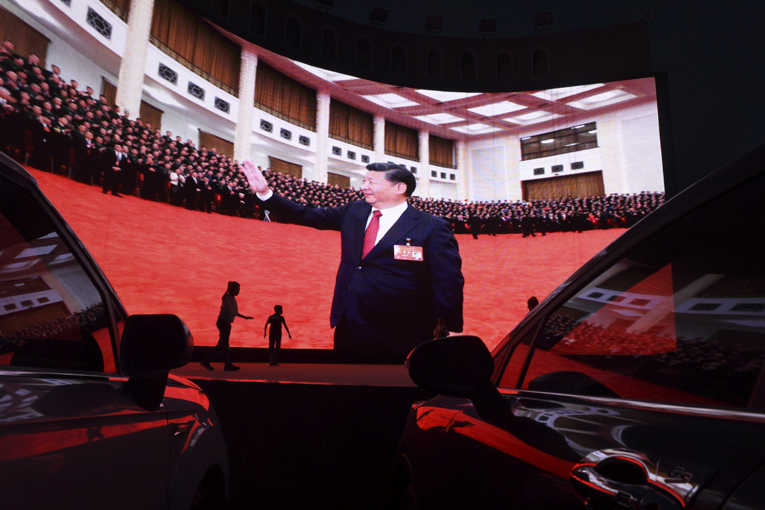 2019年6月1日，中国西部新疆地区喀什一幅屏幕上播放国家主席习近平片段，孩子们在屏幕旁玩耍。