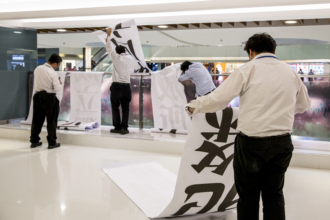 2019年12月1日,有市民在新城市廣場掛上多條直幡,其後保安將其收起。