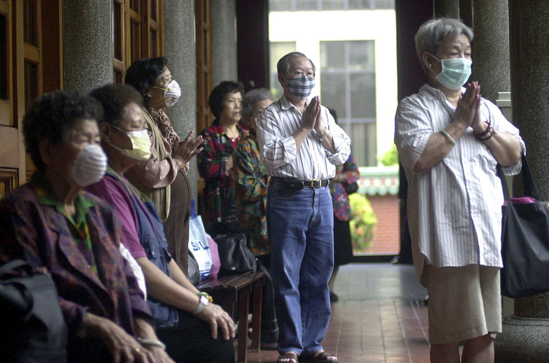 2003年5月18日,一群台北市民在寺廟參拜時戴上口罩。