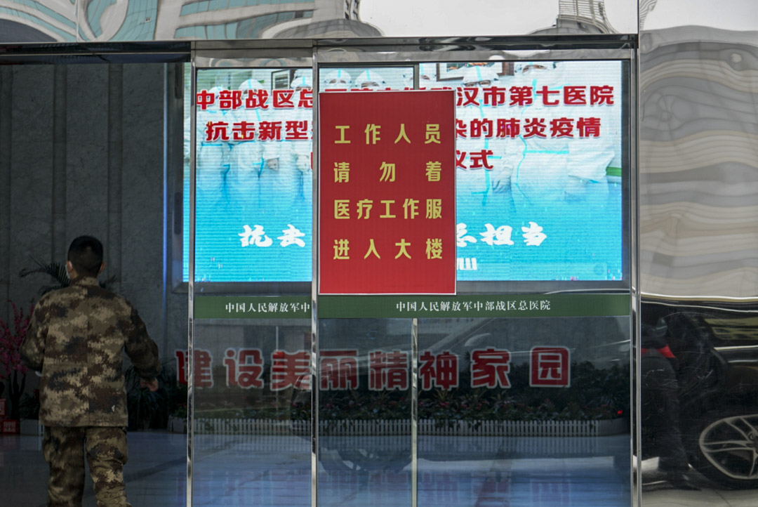 2020年1月26日,武漢市中部戰區總醫院醫護人員從志願者處領取物資。