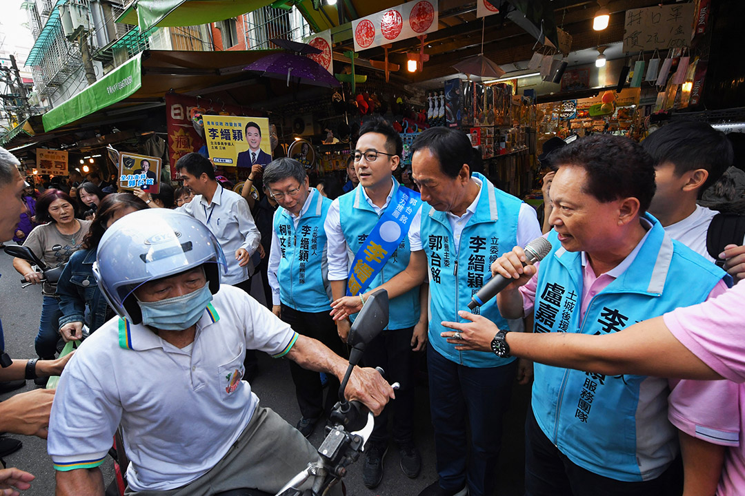 2019年11月9日,台灣民眾黨主席、台北市長柯文哲(前右4)、鴻海創 辦人郭台銘(前右2)陪同無黨籍立委參選人李縉穎 (前右3)到土城學府市場掃街拜票,爭取民眾支持。