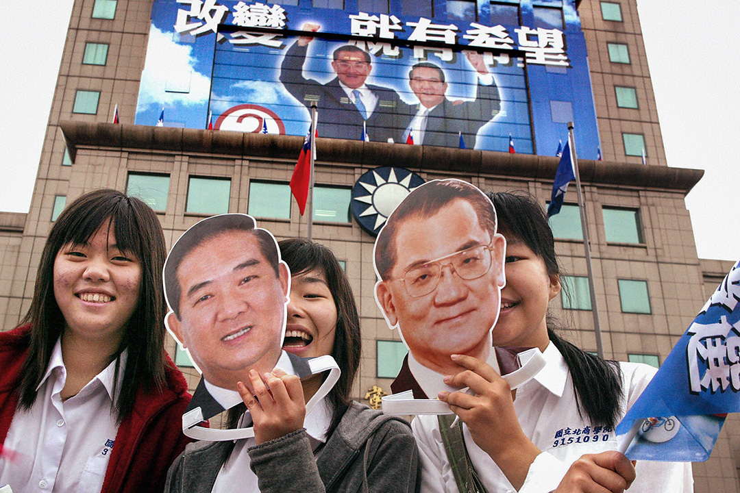 2004年3月19日,女孩在台北國民黨總部前舉起台灣總統候選人連戰和副總統候選人宋楚瑜的面具。