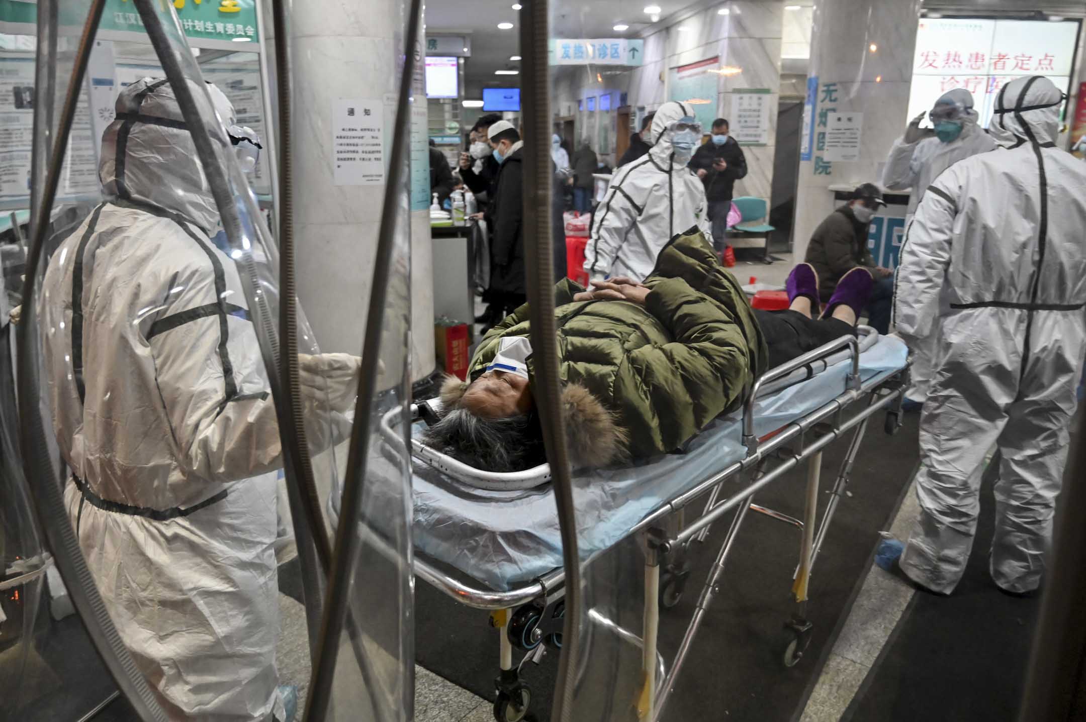 2020年1月25日，一名病人到達武漢市紅十字會醫院，由穿上防護衣的醫務人員帶進醫院。