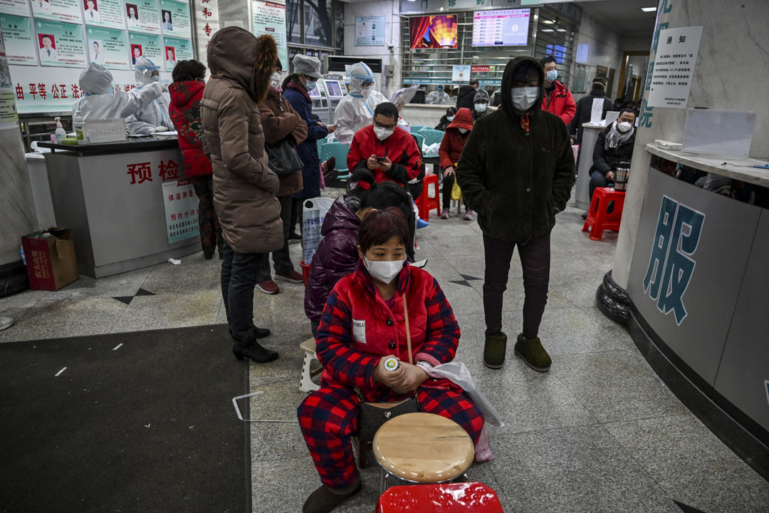 2020年1月25日,人們戴著口罩在武漢市紅十字會醫院等待醫療救助。