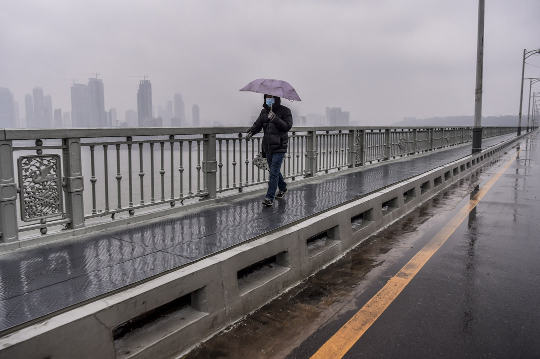 2020年1月25日,一名戴著口罩的男子在武汉的一座桥上行走。