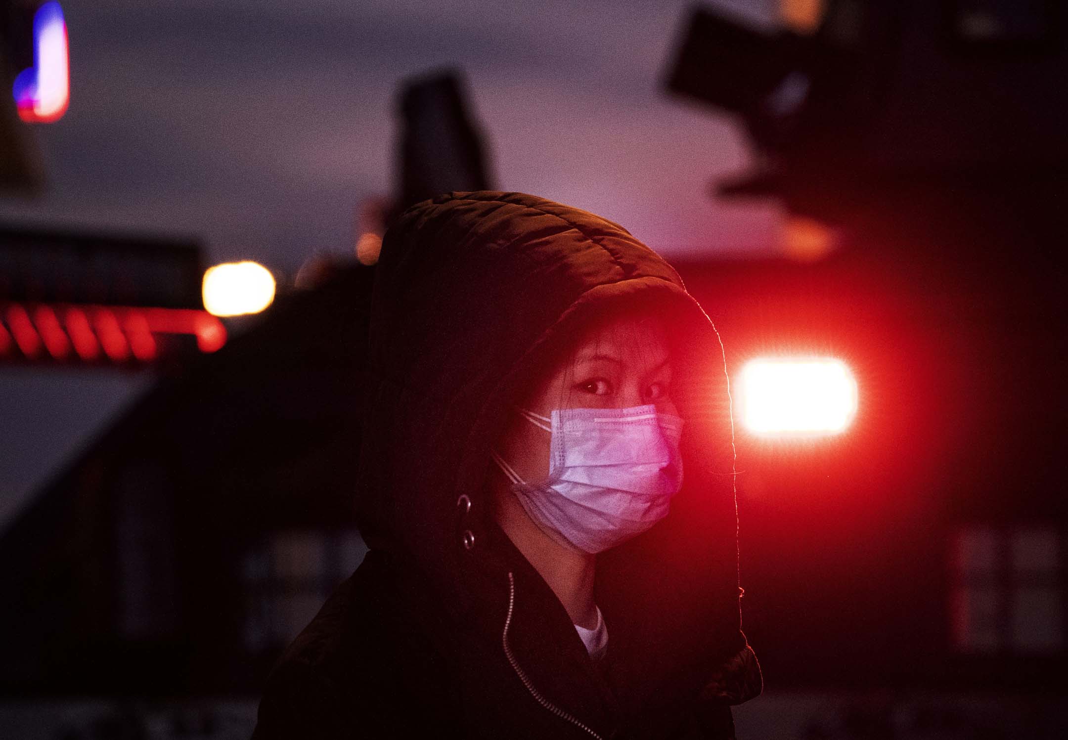 2020年1月21日,春節前夕,一名戴著口罩的女士站在北京火車站一架警車的旁邊。
