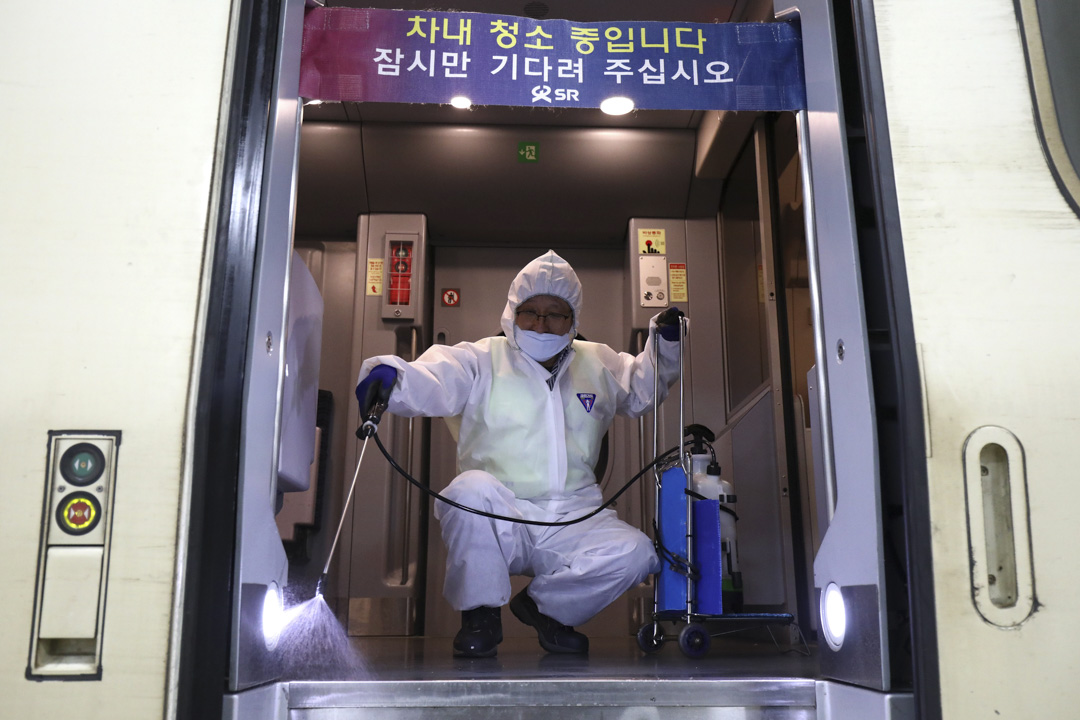2020年1月24日,南韓首爾一個火車站,一名戴著防護裝備的消毒工作者在火車上噴灑消毒液。